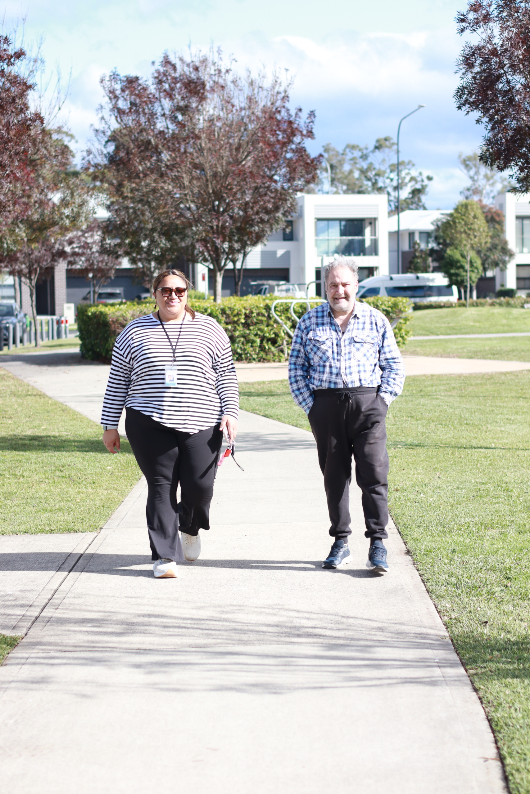 Aligned community care support worker walking alongside a participant promoting wellbeing for NDIS psychosocial diability support