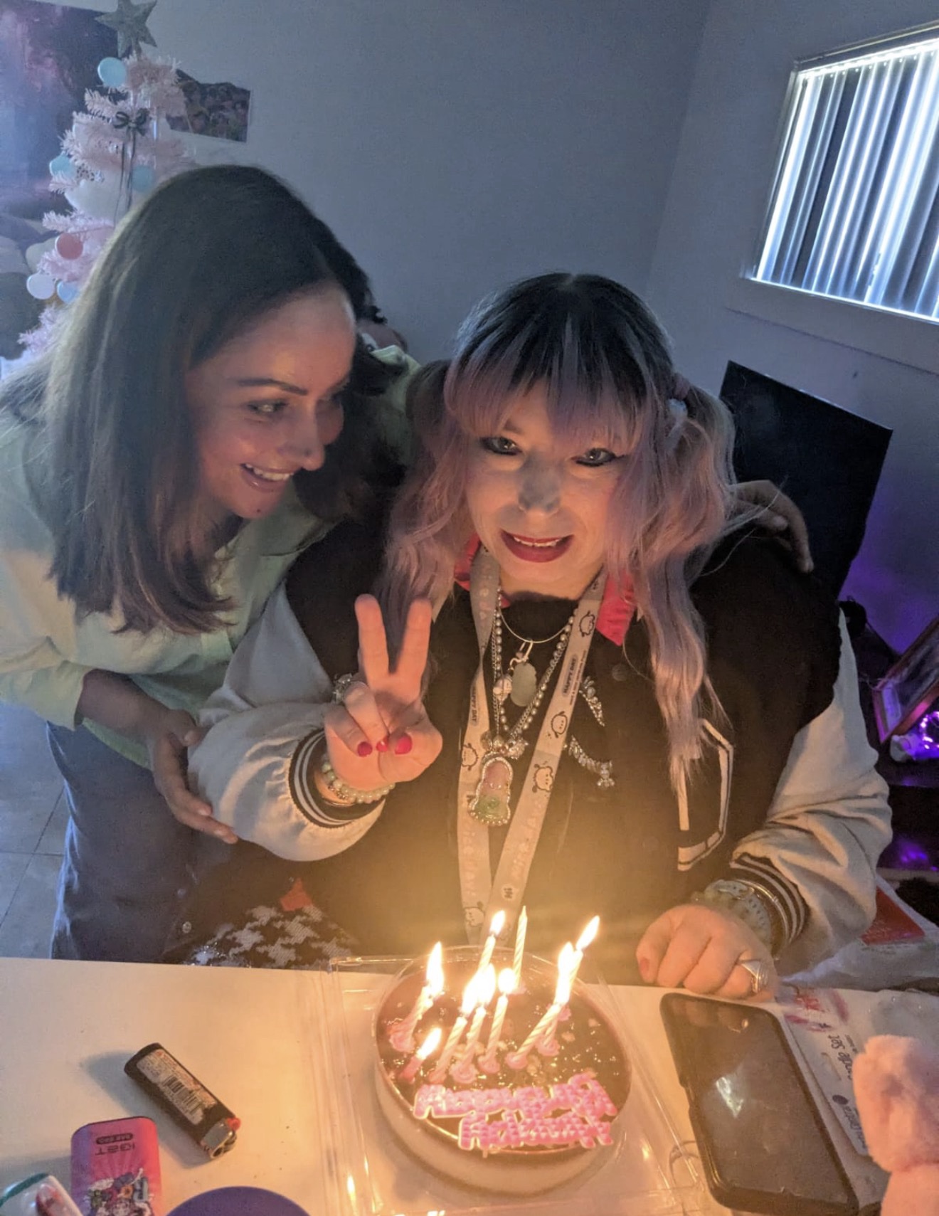 A support worker and NDIS participant sharing a happy moment together at a table in their SIL home promoting independence and support through Aligned Community care